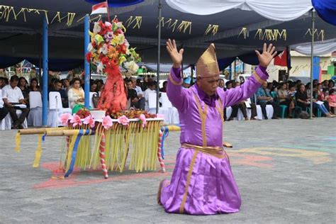 A Man In A Purple Outfit Is Dancing With His Hands Up While People