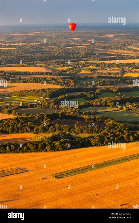 Distant View Of Red Hot Air Balloon Flying Over Rural Landscape South Oxfordshire England