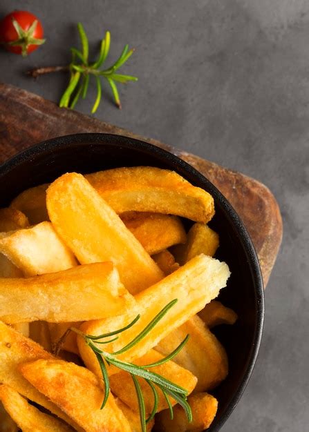 Vista superior de batatas fritas em uma tigela ervas Foto Grátis