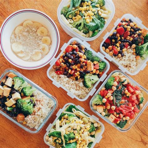 Six Plastic Containers Filled With Food On Top Of A Wooden Table Next