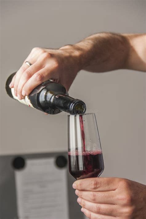 Vinho Tinto De Derramamento Do Homem Da Garrafa Imagem De Stock