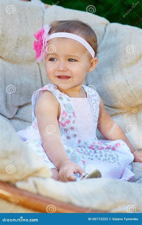 Petite Fille Heureuse S Asseyant Sur Le Divan Et Le Sourire Photo Stock