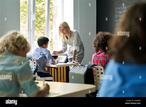 Happy Blonde Teacher Explaining Maths At Lesson To Student Education Concept Stock Photo Alamy