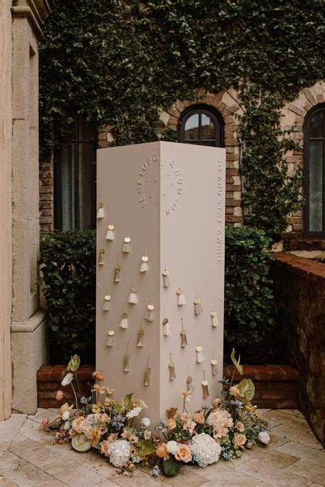 A Large White Box With Flowers On The Ground In Front Of A Brick