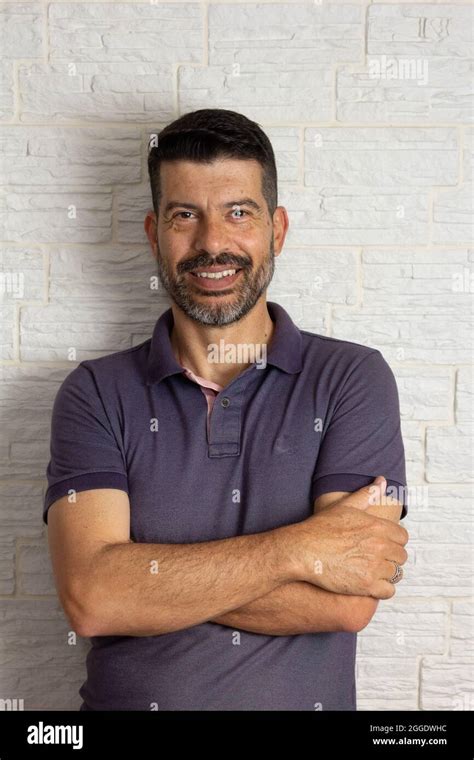 Portrait Of Joyful Mature Man With Arms Crossed And Looking At Camera