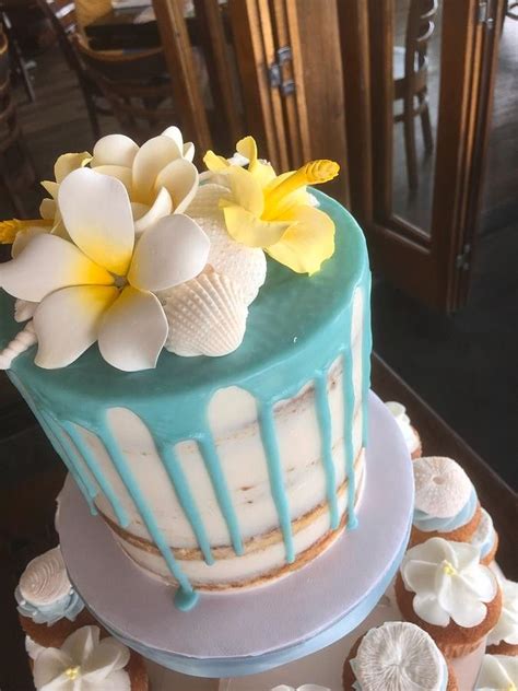 A Blue And White Cake With Flowers On Top