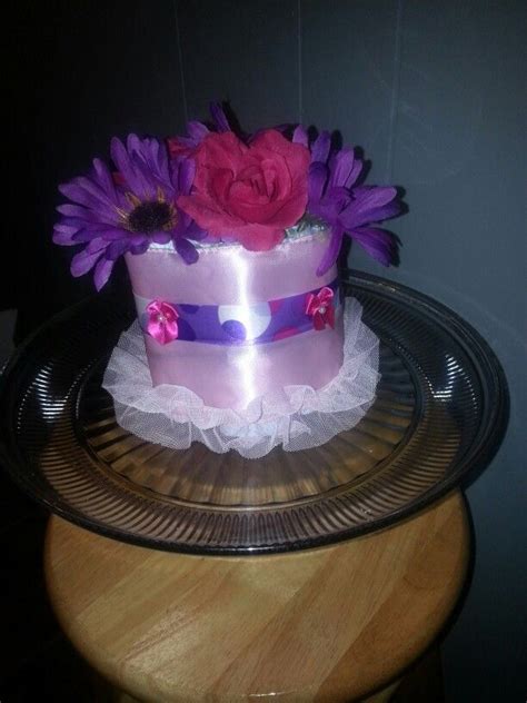 A Pink And Purple Cake With Flowers On Top