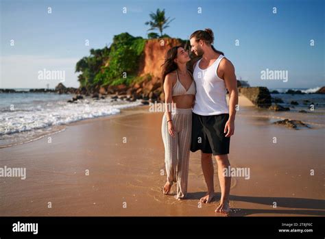 Romantic Pair Strolls On Sandy Beach By Sea At Sunset Affectionate Man