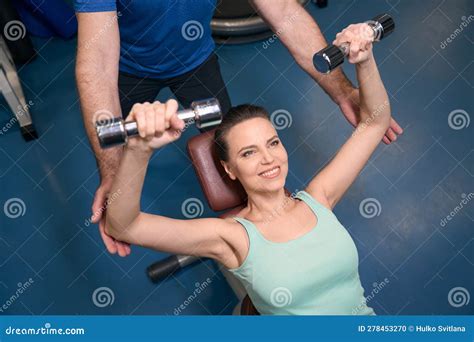 Cheerful Mature Athletic Woman Doing Upper Body Exercise With Weights
