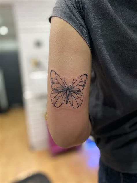 A Person With A Butterfly Tattoo On Their Arm