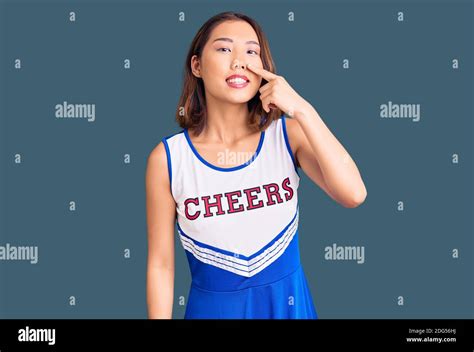 Young Beautiful Chinese Girl Wearing Cheerleader Uniform Pointing With