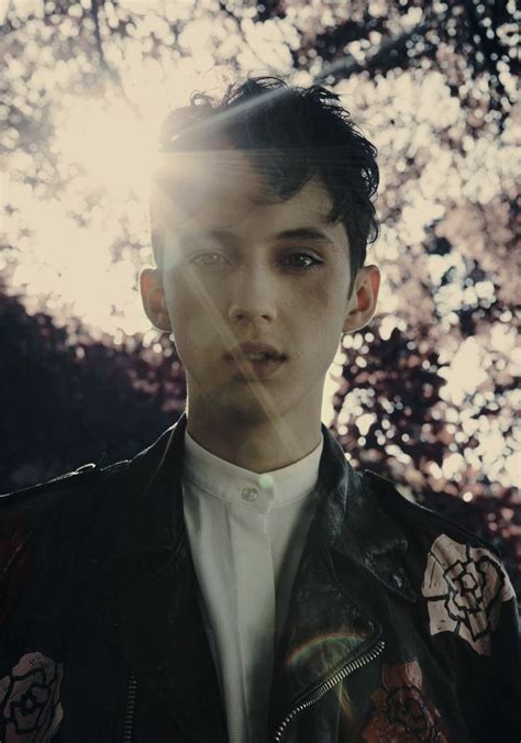 A Young Man Is Standing In Front Of Some Trees And Sun Shining Through