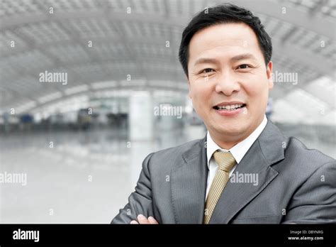 Mature Businessman With Arms Crossed In Airport Lobby Stock Photo Alamy