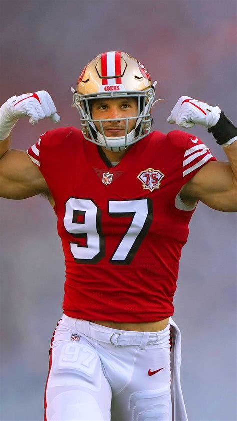 A Man In A Football Uniform Holding His Hands Up