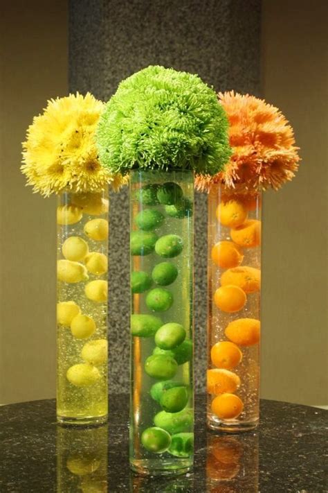 Three Vases Filled With Different Types Of Flowers And Fruits In Them