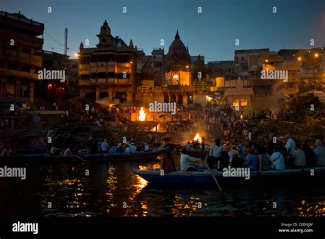 Tourists watch Hindu cremation on funeral pyre at Manikarnika Ghat ...