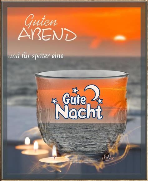 A Cup With Candles On The Beach In Front Of An Orange And Blue Sunset