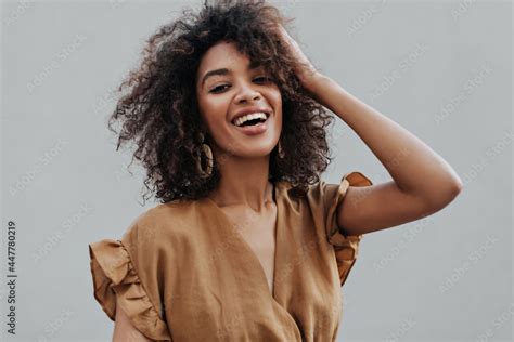 Photo Stock Portrait Of Curly Brunette African Dark Skinned Woman In Beige Top Smiling And