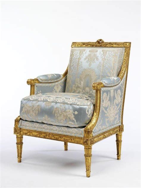 An Ornately Decorated Chair With Gold Trimmings And Blue Upholstered Fabric