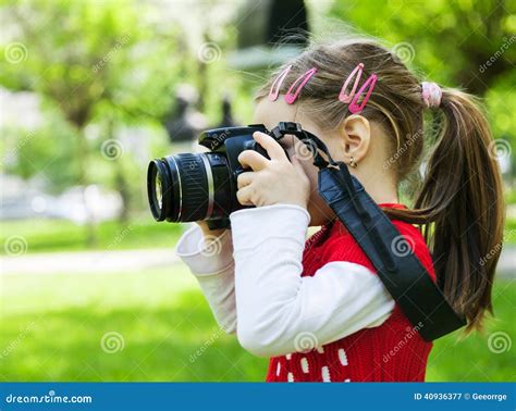 Девушка которая фотографирует с камерой фото в парке Стоковое