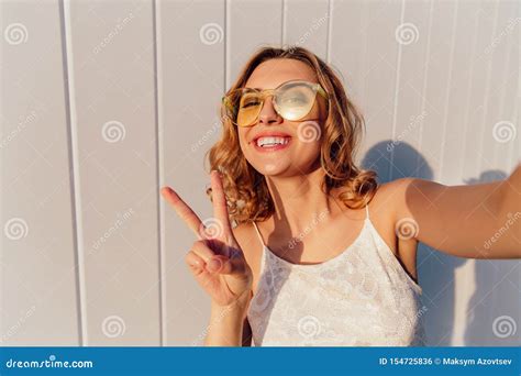 Attractive Girl Showing A Peace Sign While Taking A Selfie Outdoors