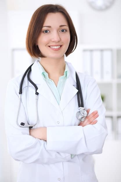 Premium Photo Young Brunette Female Doctor Standing With Arms Crossed