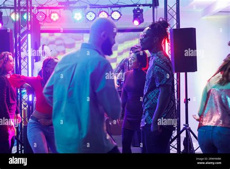 People Partying On Crowded Dancefloor In Dark Nightclub Illuminated