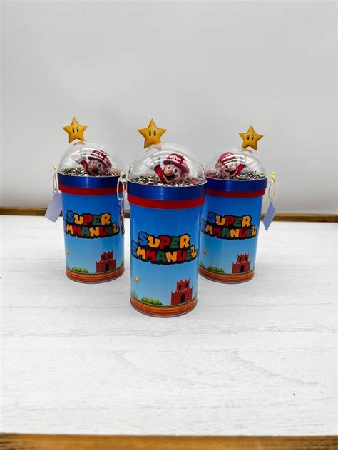 three plastic cups filled with candy sitting on top of a white table ...