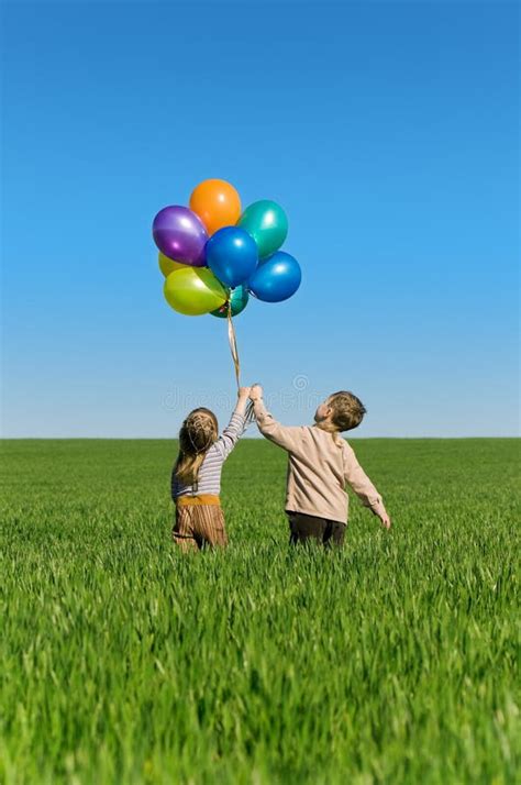 Enfants Avec Des Ballons Marchant Sur Le Gisement De Ressort Image