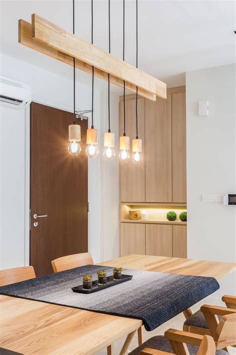 A Dining Room Table And Chairs With Lights Hanging From The Ceiling