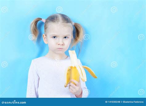 Peu Fille Avec Les Cheveux Blonds Sur Un Fond Bleu L Enfant Mange Une