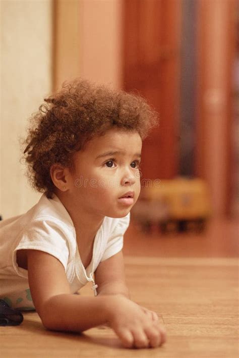 Fille Mignonne De Petit Afro américain S étendant Sur Le Plancher Avec