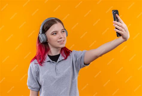 Free Photo Pleased Young Beautiful Girl Wearing Gray T Shirt In Headphones Taking Selfie On