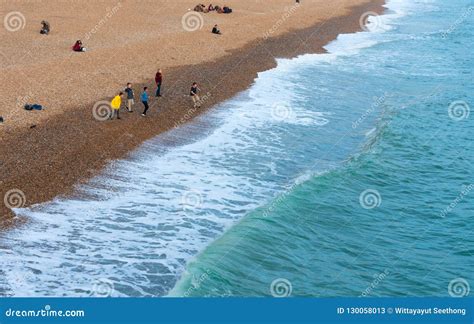 Group Of Young Boy Throwing And Skipping Stones Across The Water At
