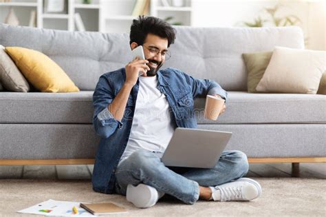 Ndio Fazendo Telefonema Tomando Caf E Usando Laptop Em Casa Imagem De