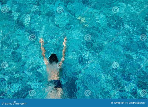 Muchacho Adolescente Que Nada Bajo El Agua En Una Piscina Al Aire Libre Imagen De Archivo