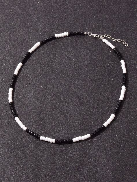 A Black And White Beaded Necklace On A Table