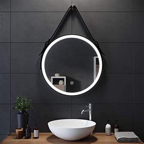 a bathroom with a round mirror above the sink and various items on the ...