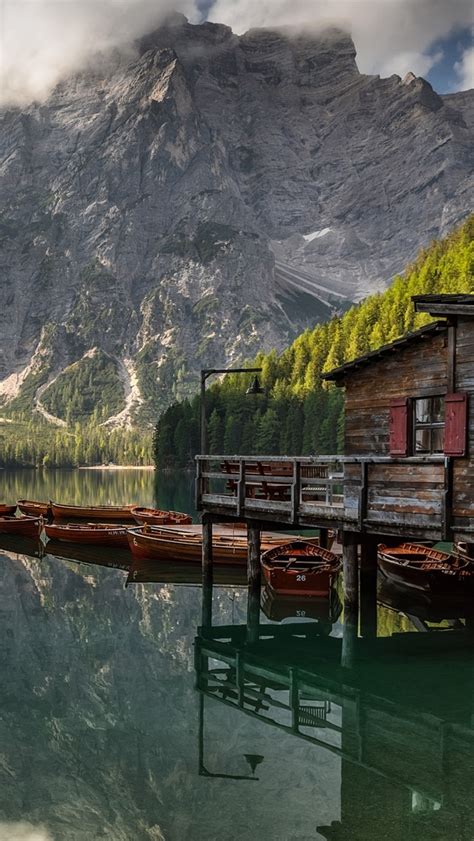 Dom na palach i łódki na jeziorze Pragser Wildsee Tapeta na telefon