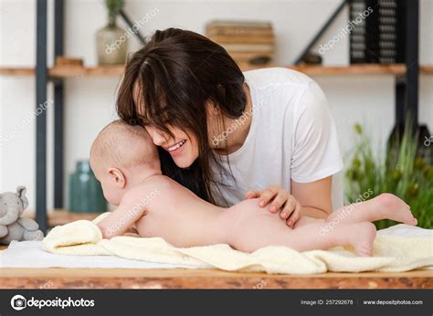 Feliz mamá sonriente abrazo niña desnuda Foto de stock 257292678