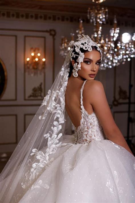 A Woman In A Wedding Dress With A Veil On Her Head