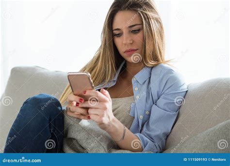 Beautiful Young Woman Using Her Mobile Phone At Home Stock Image