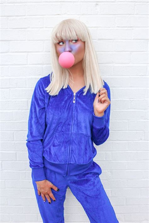 a woman with blonde hair wearing blue pajamas and blowing a pink bubble ...