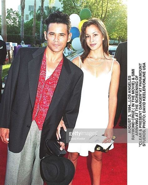 A Man And Woman Standing On A Red Carpet