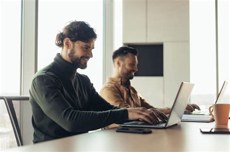 Colegas De Trabalho Masculinos Alegres Usando Laptops Trabalhando Em