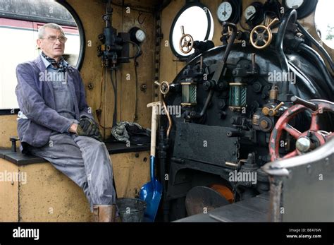 Steam Engine Driver Sitting In Cab On Footplate Of Steam Train Stock