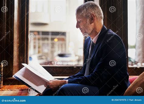 Relaxing At His Favorite City Spot A Well Dressed Mature Man Reading A