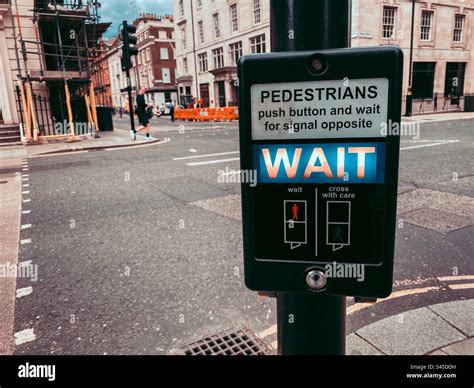 A Button And Display At A Pedestrian Crossing Telling Pedestrians To