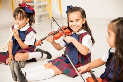 Ritratto di una ragazza latina carina che impara a suonare il violino e si diverte in età