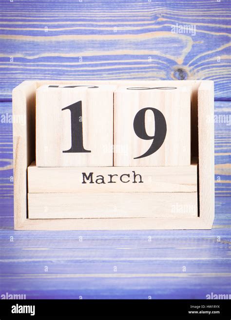 March 19th. Date of 19 March on wooden cube calendar, purple board as ...